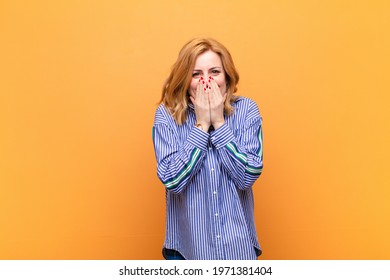 middle age woman looking happy, cheerful, lucky and surprised covering mouth with both hands