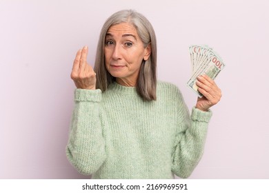 Middle Age Woman Making Capice Or Money Gesture, Telling You To Pay. Dollar Banknotes Concept