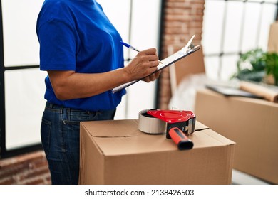 Middle Age Woman Moving Worker Writing On Checklist At New Home