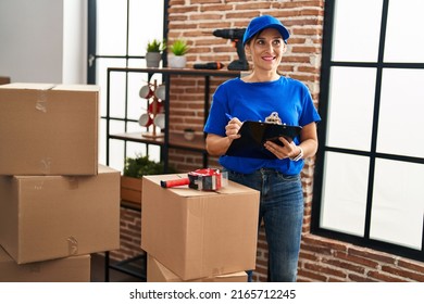 Middle Age Woman Moving Worker Writing On Checklist At New Home