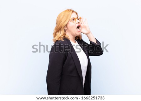 middle age woman profile view, looking happy and excited, shouting and calling to copy space on the side