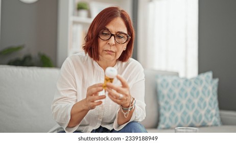 Middle age woman reading pills bottle information at home - Powered by Shutterstock