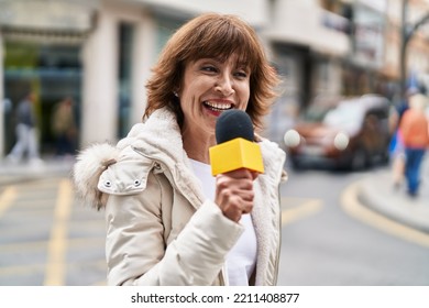 Middle Age Woman Reporter Working Using Microphone At Street