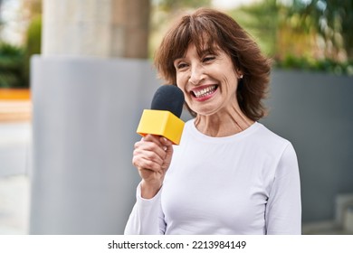 Middle Age Woman Reporter Working Using Microphone At Street