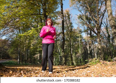 Middle Age Woman Running In The Forest