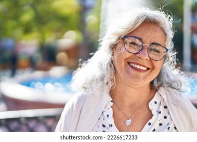 Middle age woman smiling confident standing at park - Powered by Shutterstock