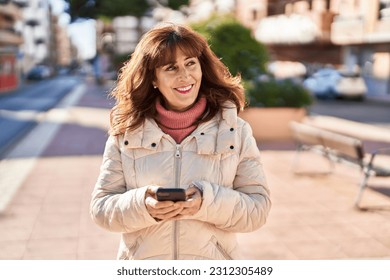 Middle age woman smiling confident using smartphone at park - Powered by Shutterstock