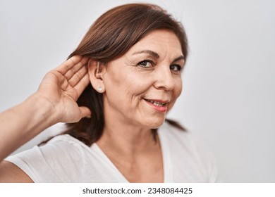 Middle age woman smiling confident using hearing aid at home - Powered by Shutterstock