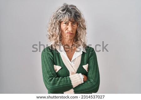 Middle age woman standing over white background skeptic and nervous, frowning upset because of problem. negative person. 