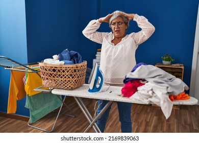 Middle Age Woman Stressed Doing Chores At Laundry Room