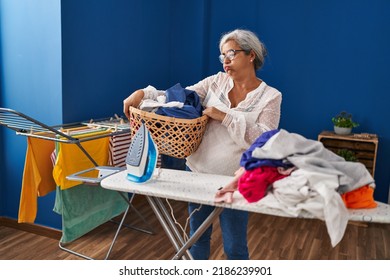 Middle Age Woman Stressed Doing Chores At Laundry Room