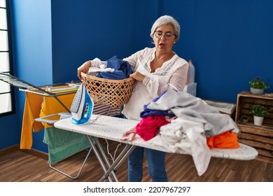 Middle Age Woman Stressed Doing Chores At Laundry Room