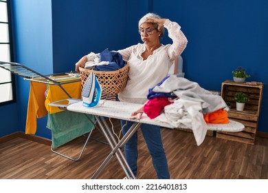 Middle Age Woman Stressed Doing Chores At Laundry Room