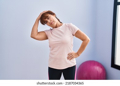 Middle Age Woman Stretching Head At Sport Center