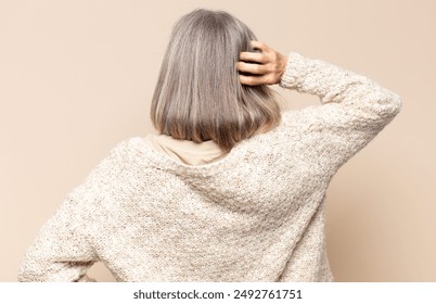 middle age woman thinking or doubting, scratching head, feeling puzzled and confused, back or rear view - Powered by Shutterstock