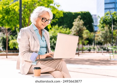 middle age woman using laptop sitting outdoors - Powered by Shutterstock