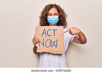 Middle Age Woman Wearing Coronavirus Protection Mask Holding Act Now Protest Cardboard Smiling Happy Pointing With Hand And Finger