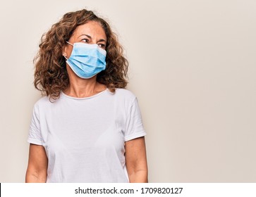 Middle Age Woman Wearing Coronavirus Protection Mask For Covid-19 Epidemic Virus Looking To Side, Relax Profile Pose With Natural Face And Confident Smile.