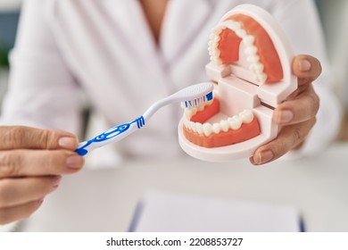 Middle Age Woman Wearing Dentist Uniform Teaching To Wash Tooth At Clinic