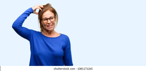 Middle Age Woman Wearing Wool Sweater And Glasses Doubt Expression, Confuse And Wonder Concept, Uncertain Future Isolated Blue Background