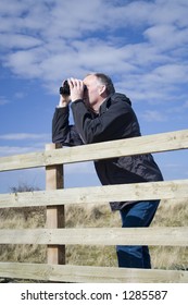 Middle Aged Adult Male Bird Watching In The Sand Dunes, UK.