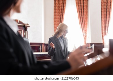 Middle Aged Advocate Pointing With Hand At Blurred Witness During Questioning In Court