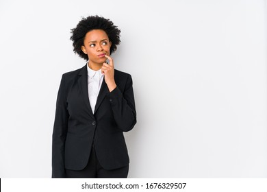 Middle Aged African American Business  Woman Against A White Background Isolated Looking Sideways With Doubtful And Skeptical Expression.