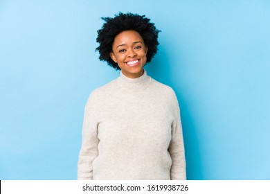 Middle Aged African American Woman Against A Blue Background Isolated Happy, Smiling And Cheerful.