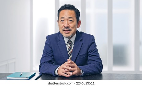 Middle aged Asian businessman talking with video call. Announcer. - Powered by Shutterstock