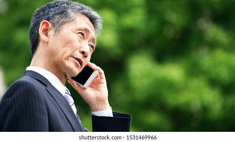 Middle Aged Asian Businessman A Using Smart Phone.