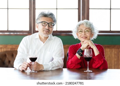 Middle Aged Asian Couple Drinking Red Wine