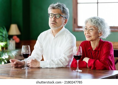 Middle Aged Asian Couple Drinking Red Wine