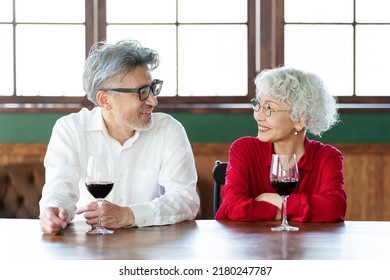 Middle Aged Asian Couple Drinking Red Wine