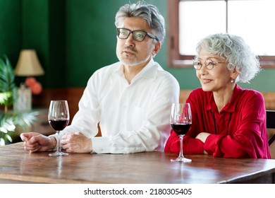 Middle Aged Asian Couple Drinking Red Wine