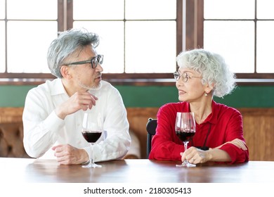 Middle Aged Asian Couple Drinking Red Wine