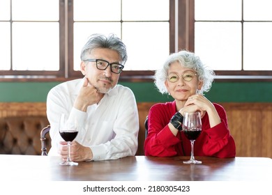 Middle Aged Asian Couple Drinking Red Wine