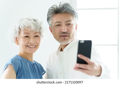 Middle Aged Asian Couple Taking Selfie With Smart Phone