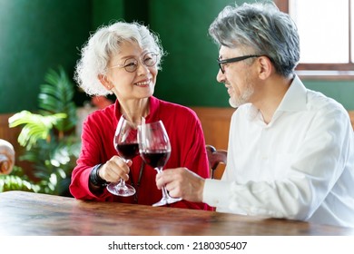 Middle Aged Asian Couple Toasting With Red Wine