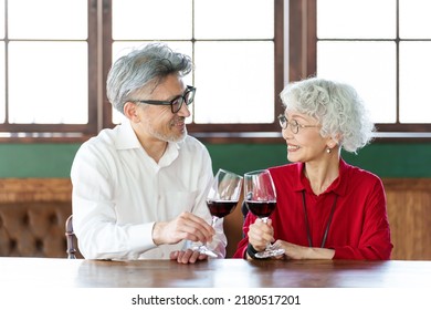 Middle Aged Asian Couple Toasting With Red Wine