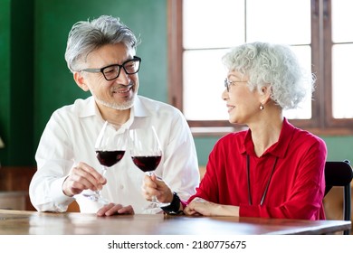 Middle Aged Asian Couple Toasting With Red Wine