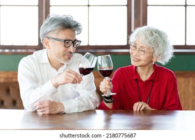 Middle Aged Asian Couple Toasting With Red Wine