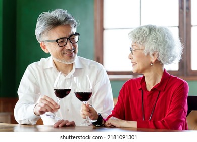 Middle Aged Asian Couple Toasting With Red Wine