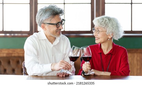 Middle Aged Asian Couple Toasting With Red Wine