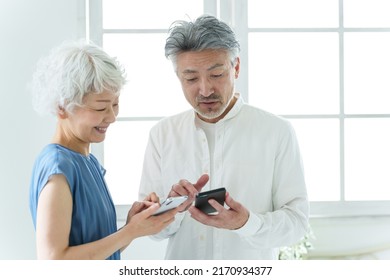 Middle Aged Asian Couple Using Smart Phone