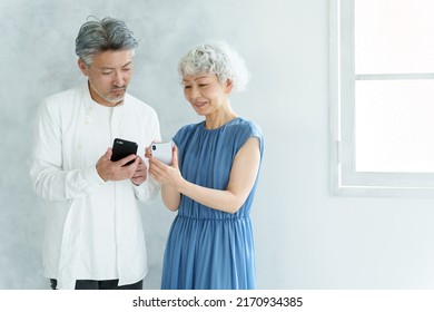 Middle Aged Asian Couple Using Smart Phone