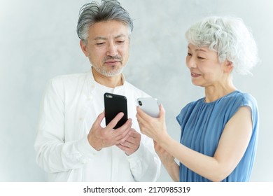 Middle Aged Asian Couple Using Smart Phone