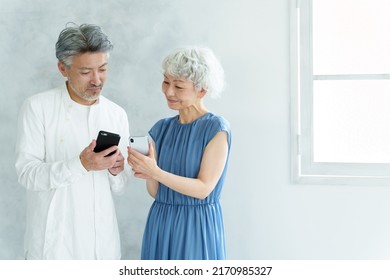 Middle Aged Asian Couple Using Smart Phone