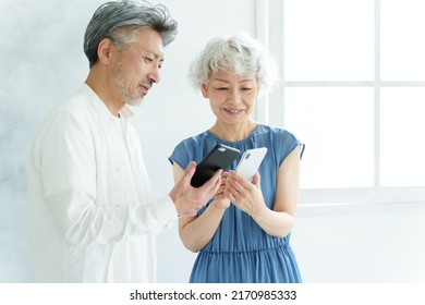 Middle Aged Asian Couple Using Smart Phone