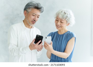 Middle Aged Asian Couple Using Smart Phone