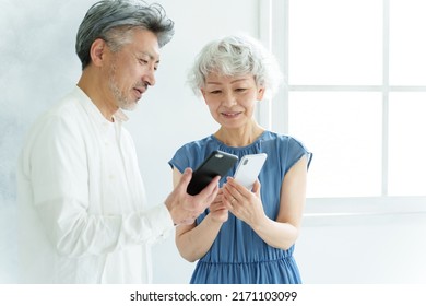 Middle Aged Asian Couple Using Smart Phone